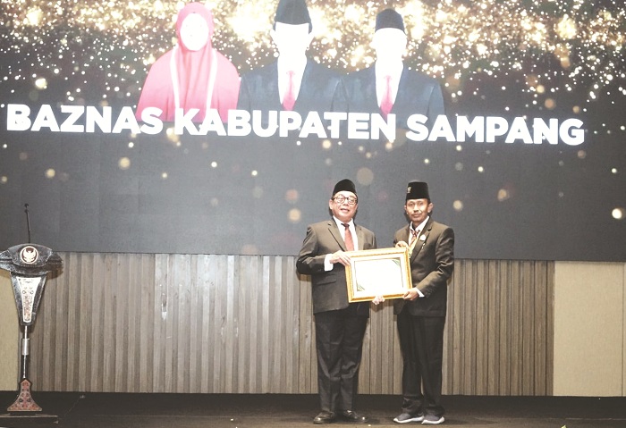 MEMBANGGAKAN: Ketua Baznas Sampang KH. Rouf Alhitami (kanan) menerima penghargaan dari ketua Baznas Jatim di Hotel Golden Tulip, Kota Batu, pada Rabu (23/10). (JUNAIDI PONDIYANTO/JPRM)