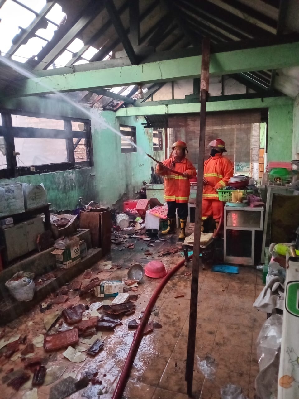 HANGUS TERBAKAR: Petugas damkar Satpol PP Bangkalan memadamkan api yang membakar rumah warga Kecamatan Arosbaya kemarin. (HORDIS ISKANDAR UNTUK JPRM)