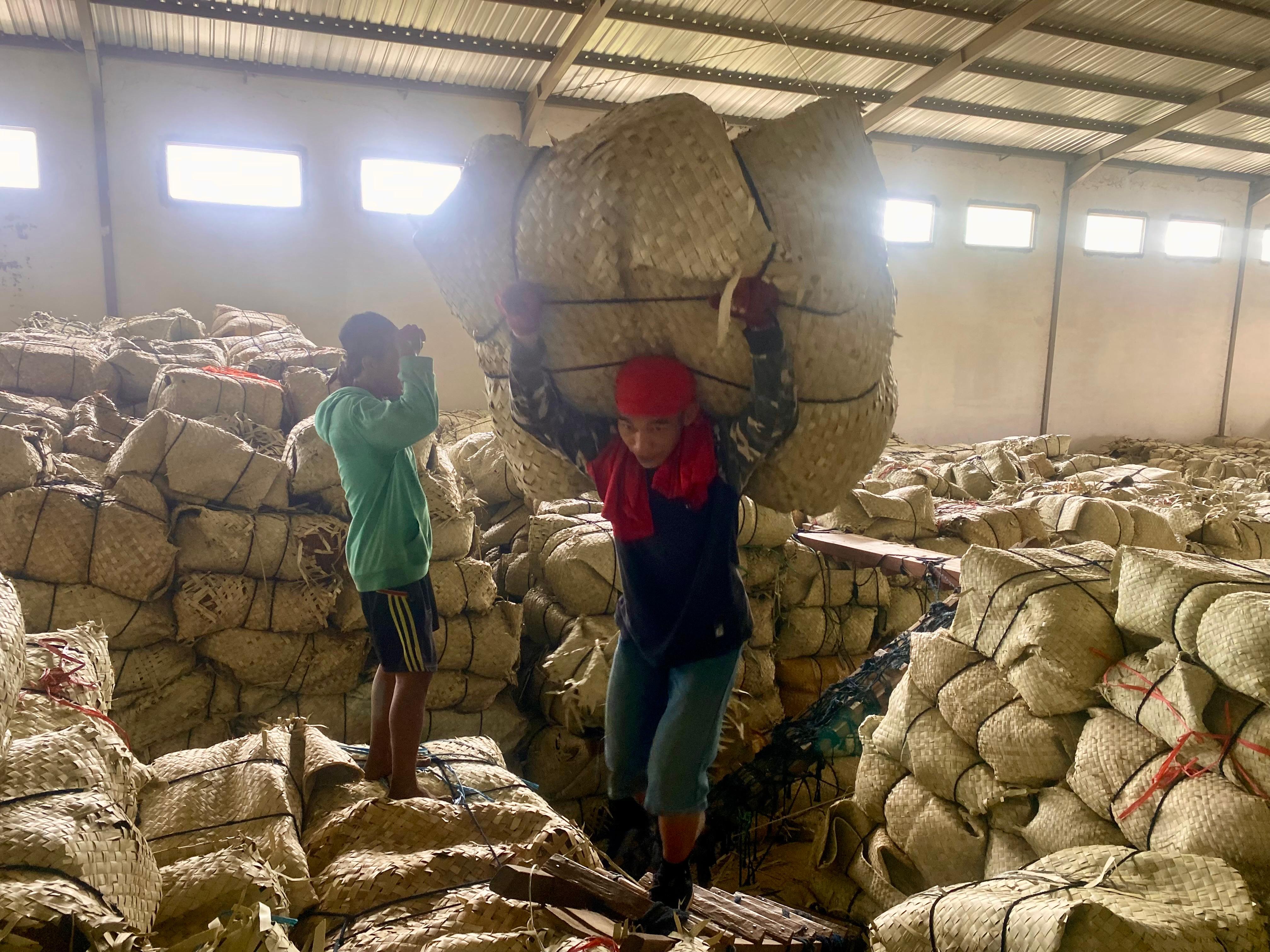BEKERJA KERAS: Pekerja memanggul tembakau kering di gudang PT Bawang Mas Group kemarin. (MOH. IQBAL AFGANI/JPRM)