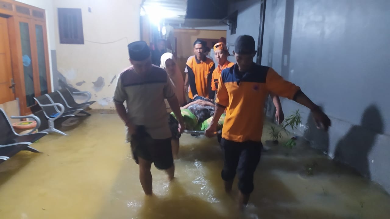 EMPATI: Seorang warga di Kelurahan Jungcangcang digotong menggunakan tandu untuk diungsikan ke lokasi yang aman saat terjadi banjir, Selasa (12/3). (BPBD UNTUK JPRM)