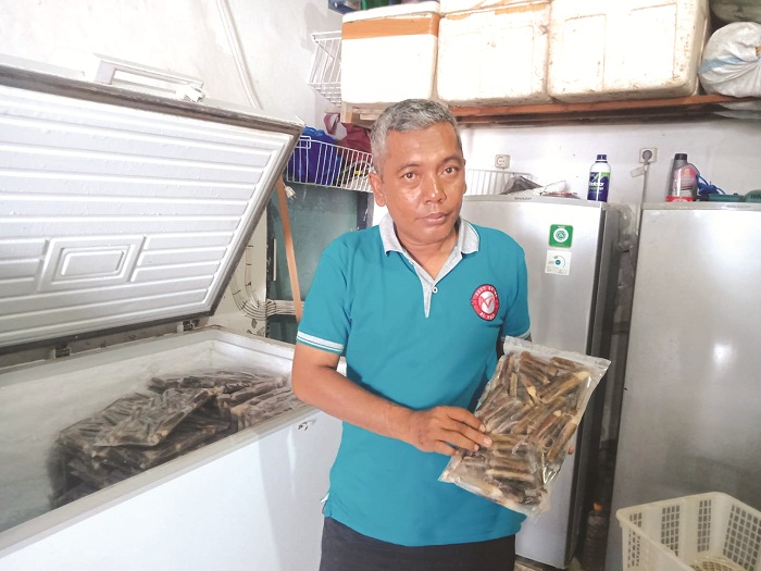 DIBEKUKAN: Nur Izat menunjukkan kerang bambu dalam proses pembekuan di Desa Pandian, Kecamatan Kwanyar, Bangkalan, Minggu (20/10). (IMAMUDIN/JPRM)