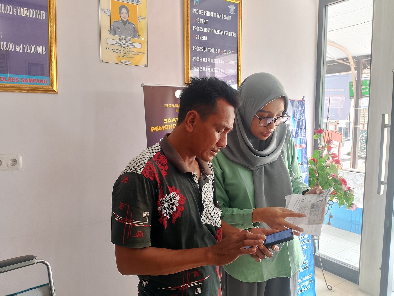 UJI COBA: Petugas BPJS Kesehatan Sampang memberikan pendampingan terhadap pemohon SIM di satpas polres Jumat (1/11). (UBAIDILLAH RAIE/JPRM)