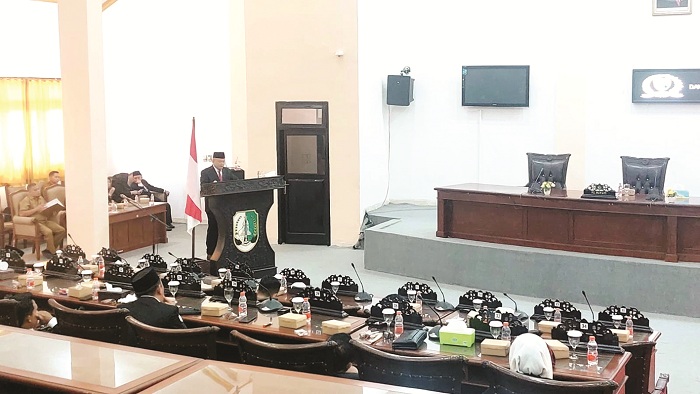 SERIUS: Pj Bupati Sampang Rudi Arifiyanto (atas mimbar) saat menyampaikan tanggapan terkait raperda penanggulangan kemiskinan di kantor dewan Senin (4/11). (JUNAIDI PONDIYANTO/JPRM)