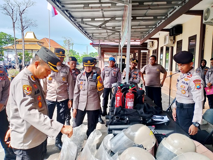 SIAP AMANKAN PILKADA: Kabag Pal Birolog Polda Jatim AKBP Muhammad Erfan didampingi Wakapolres Sampang Kompol Hosna Nurhidayah mengecek senjata di halaman Mapolres Sampang, Senin (4/11).