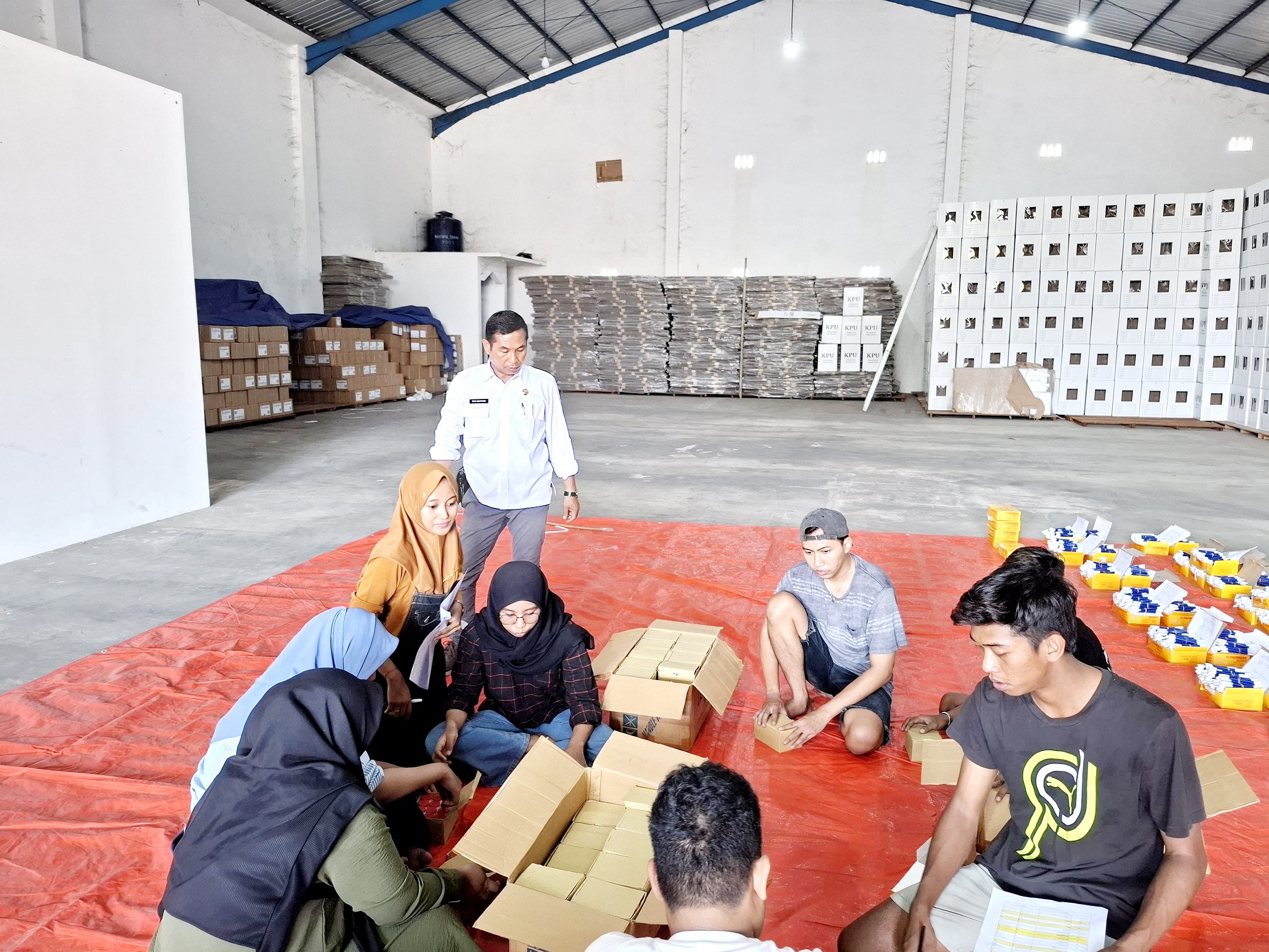 FOKUS: Sejumlah pekerja melipat surat suara pilkada di gudang logistik KPU Sumenep pada Selasa (29/10). (MOH IQBAL/JPRM)