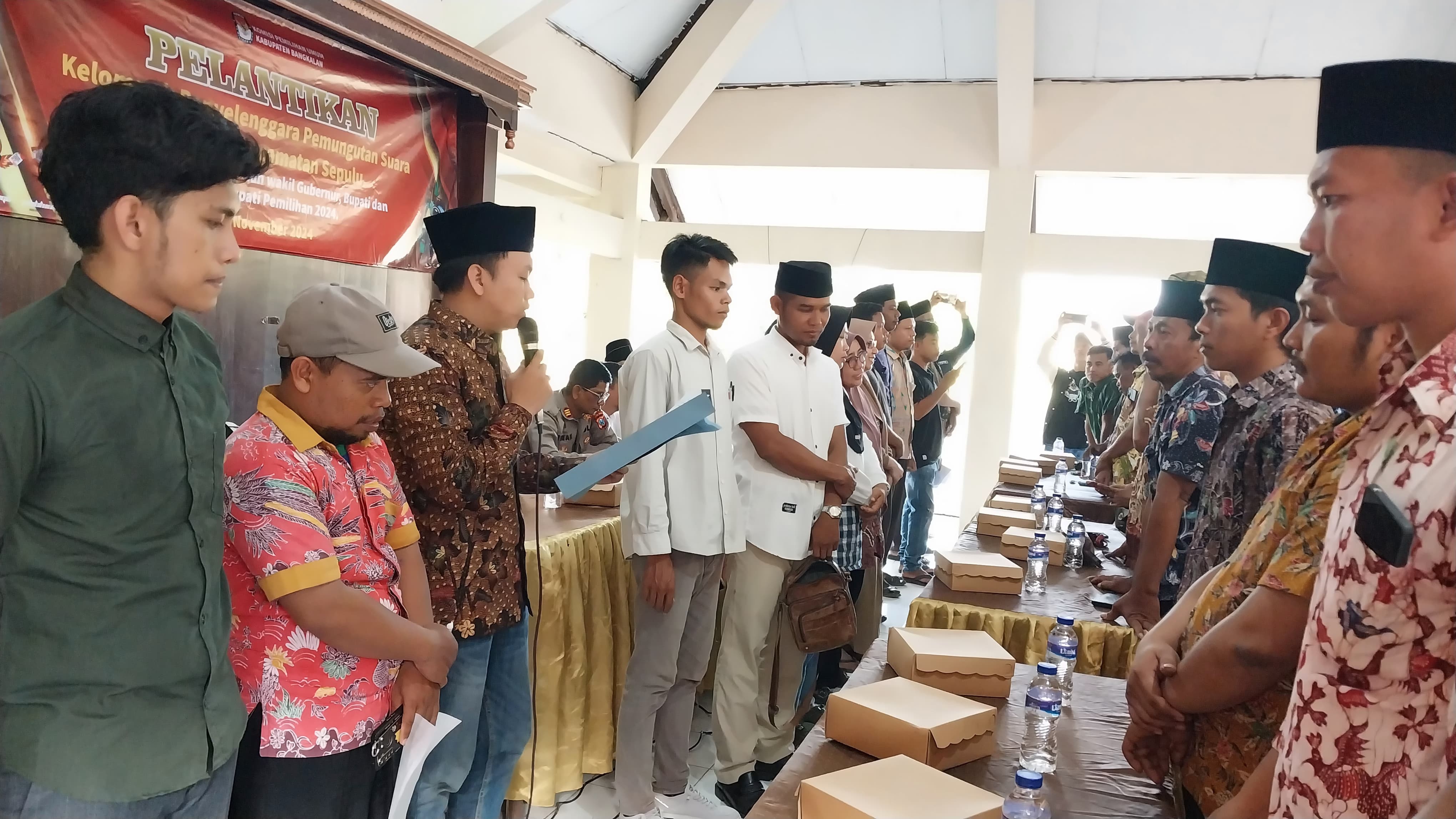 KHIDMAT: Ketua PPK Sepulu Muhammad Mukaffi mengambil sumpah dan janji jabatan ratusan anggota KPPS di pendopo kecamatan, Kamis (7/11).