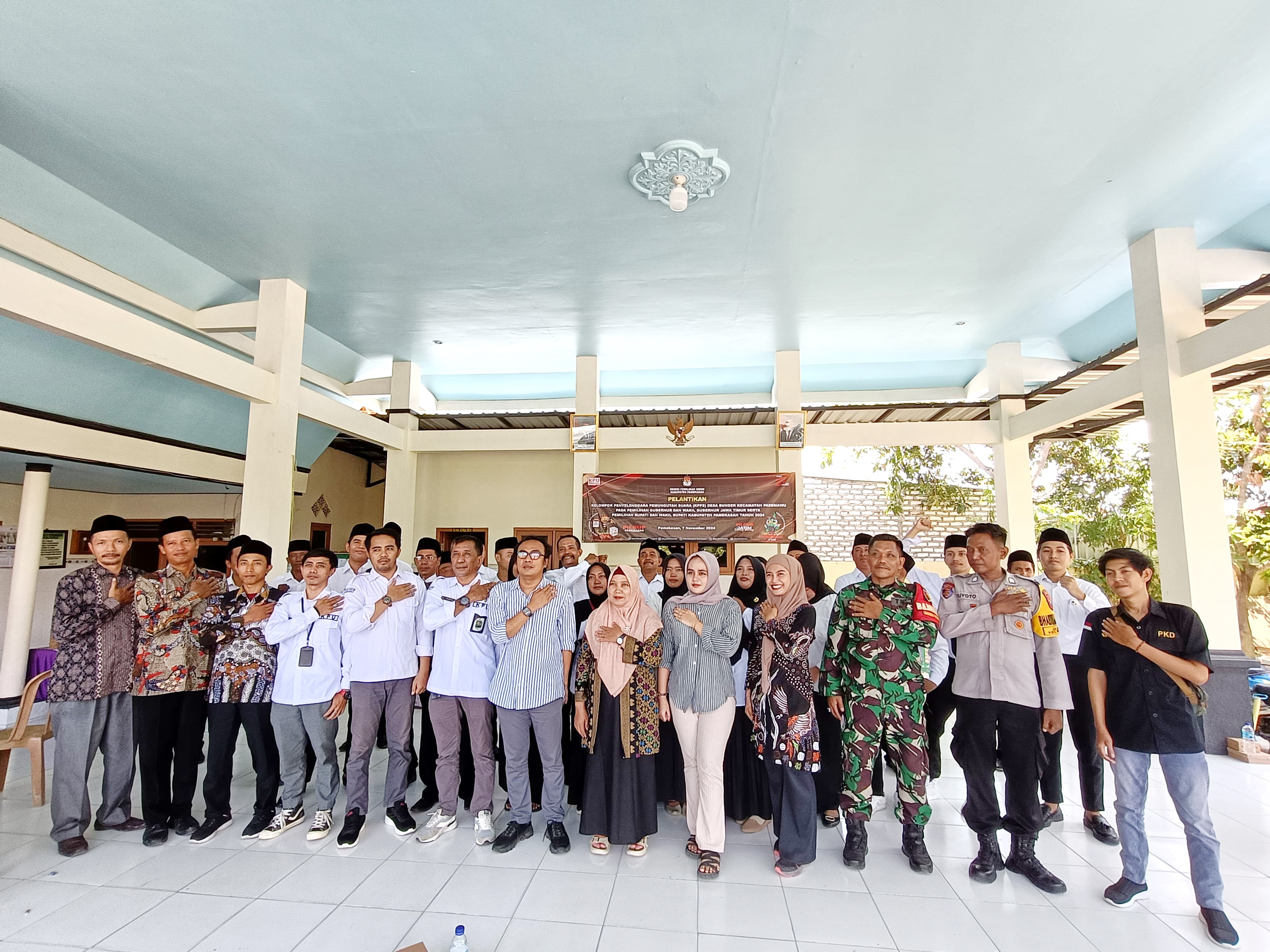 KOMPAK: Ketua Divisi Sosdiklih Parmas SDM KPU Pamekasan Moh. Amiruddin berfoto dengan Forkopimcam Pademawu, staf KPU Pamekasan, dan KPPS di Desa Bunder, Kecamatan Pademawu, kemarin. (KPU PAMEKASAN)