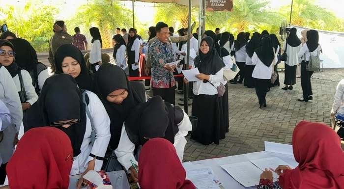 CALON PEGAWAI: Peserta rekrutmen CPNS Kabupaten Sampang mengisi daftar hadir sebelum mengikuti seleksi kompetensi dasar di Kabupaten Pamekasan Selasa (22/10). (BKPSDM UNTUK JPRM)