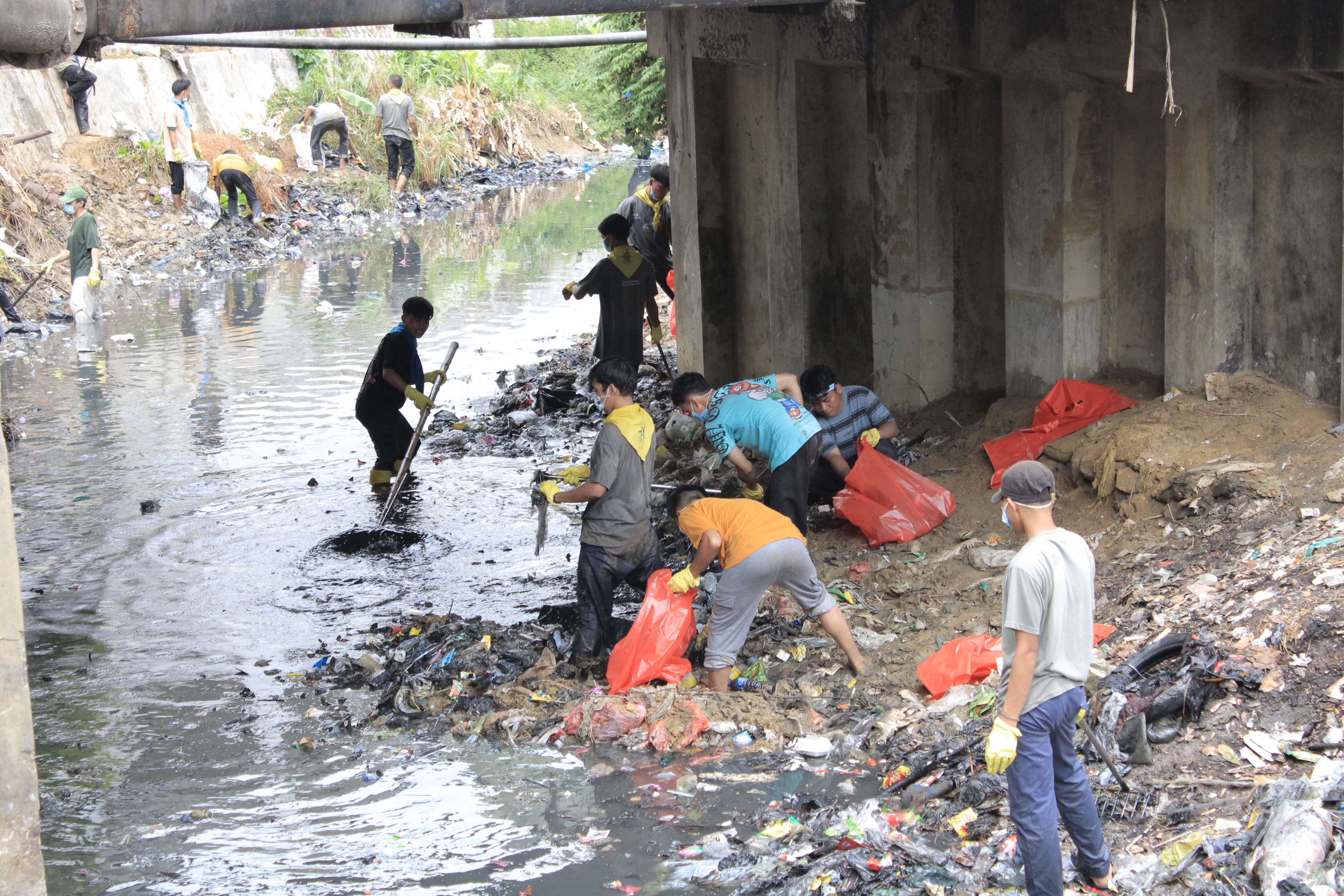 PEDULI LINGKUNGAN: Para relawan WCD Sumenep memungut sampah di sungai Jerman Prenduan, Sumenep Minggu (10/11).