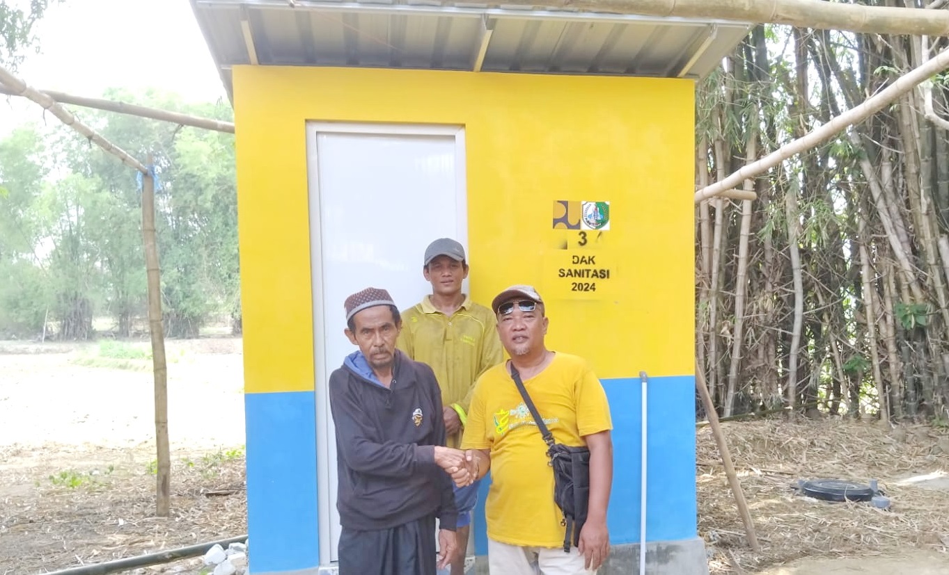 SENANG: Pegawai DPUPR berfoto bersama penerima program sanitasi yang sudah selesai dikerjakan beberapa waktu lalu. (DPUPR UNTUK JPRM)