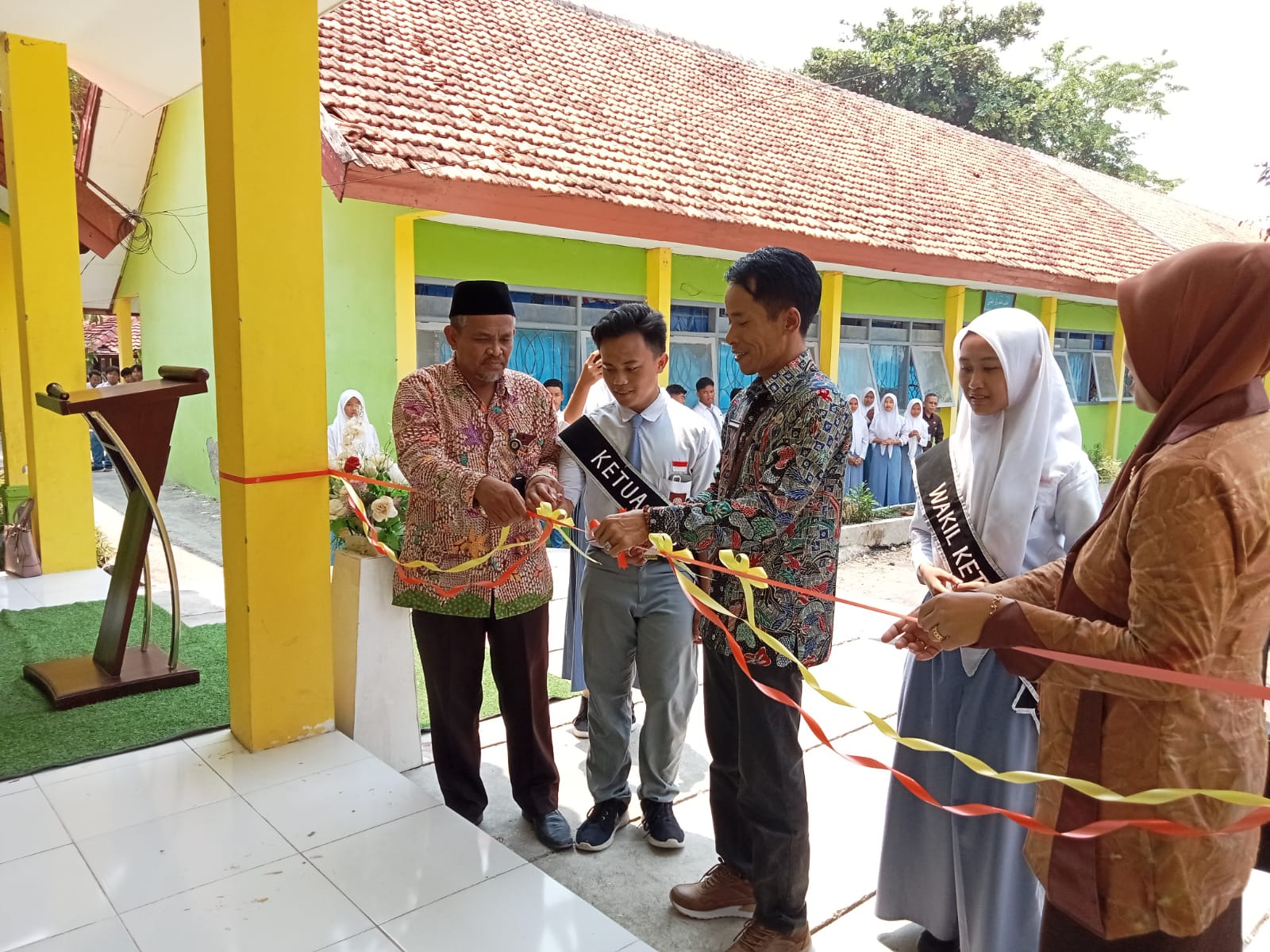 SEREMONIAL: Kepala Cabang Dinas Pendidikan (Kacabdindik) Provinsi Jawa Timur Wilayah Sampang Mas&rsquo;udi mengunting pita tanda diresmikannya dua gedung di SMAN 3 Sampang, Kamis (14/11). UBAIDILLAHIR RA&rsquo;IE