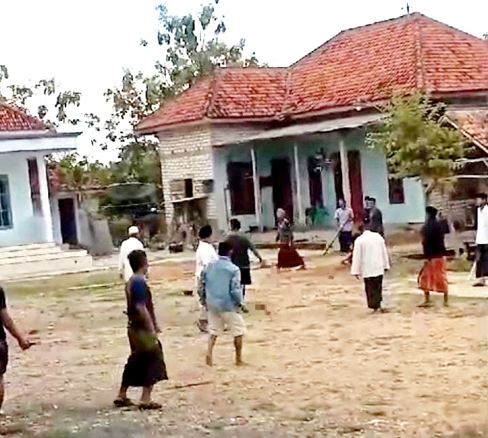 TEGANG: Sejumlah warga berada di lokasi dugaan pembacokan di Desa Ketapang Laok, Ketapang, Sampang, Minggu (17/11) sore. (Hasil tangkap layar)