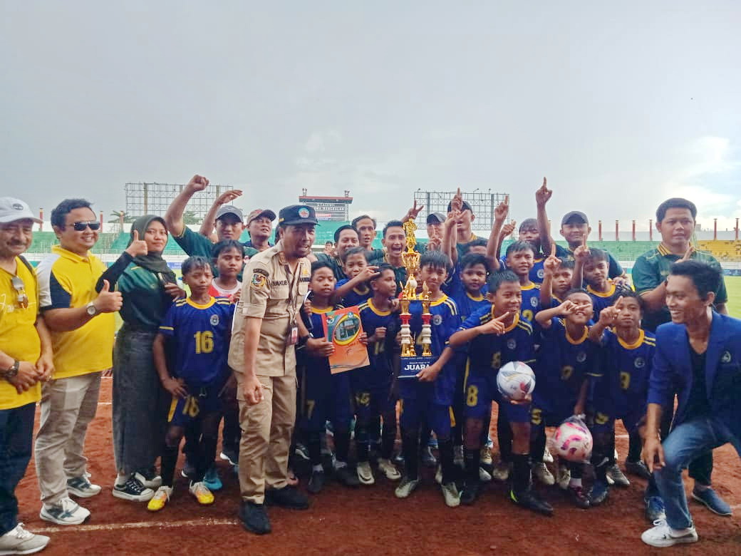 BERPRESTASI: Kepala Dispendik Bangkalan Mohammad Yakub (baju dinas) menyerahkan trofi juara 1 Piala Bupati U-12 kepada Korwil Tanjungbumi di Stadion Gelora Bangkalan, Senin (18/11). (IMAMUDIN/JPRM)
