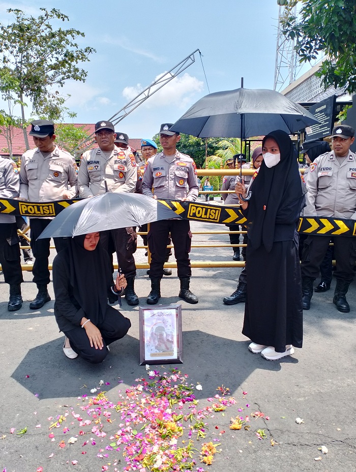 BERDUKACITA: Massa aksi melakukan tabur bunga sebagai tanda turut berdukacita di depan Mapolres Sampang, Kamis (21/11).