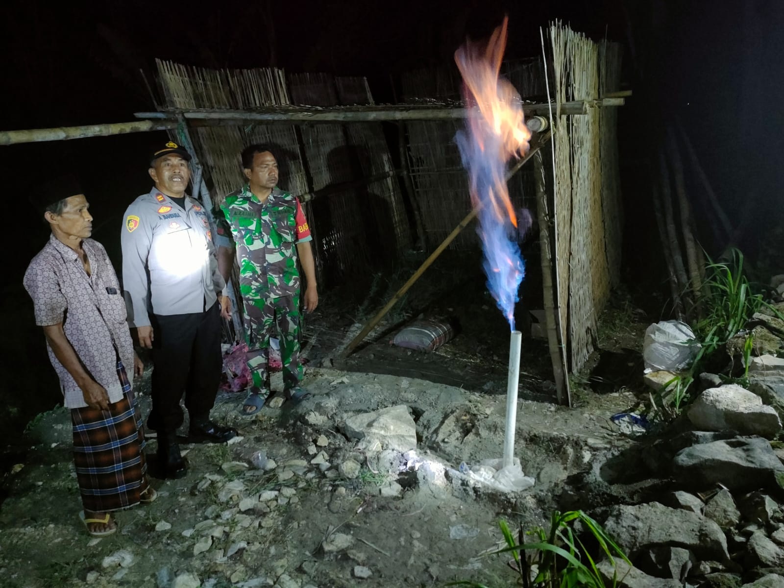 WASPADA: Petugas memantau kondisi sumur bor yang mengeluarkan gas dan api di Desa Batuputih Kenek, Kecamatan Batuputih, Sumenep, Kamis (21/11).