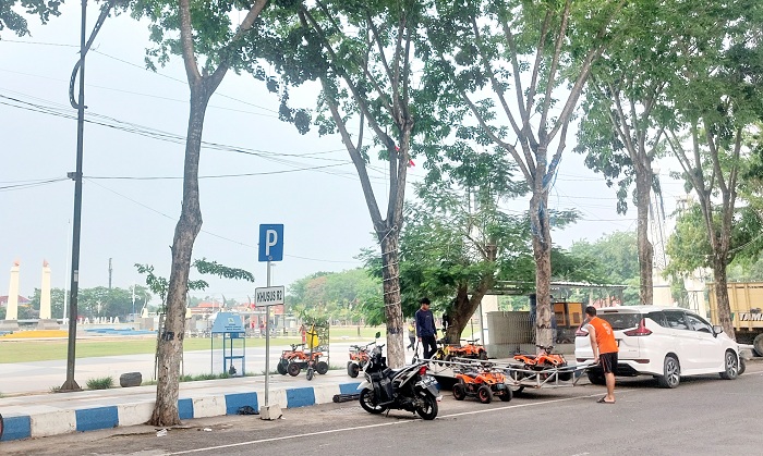 SUMBER PAD: Warga berada di area parkir di Jalan Wijaya Kusuma, Sampang, Senin (25/11). (JUNAIDI PONDIYANTO/JPRM)