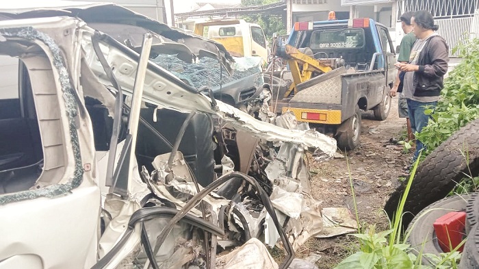 RUSAK BERAT: Warga mengevakuasi kendaraan yang mengalami laka lantas di jalan raya Desa Dumajah, Kecamatan Tanah Merah, Bangkalan, Selasa (26/11). (SATLANTAS POLRES BANGKALAN UNTUK JPRM)