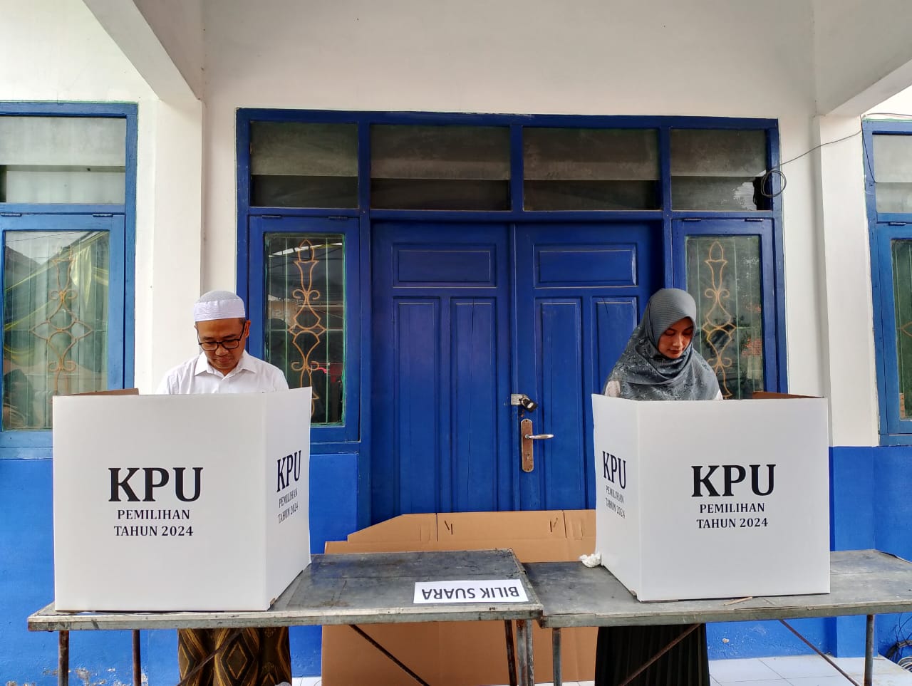 DIDAMPINGI ISTRI: Paslon Cabup nomor urut 01 Ra Mamak melakukan pencoblosan di TPS 001, Desa Prajjan, Kecamatan Camplong, Sampang, Rabu (27/11).
