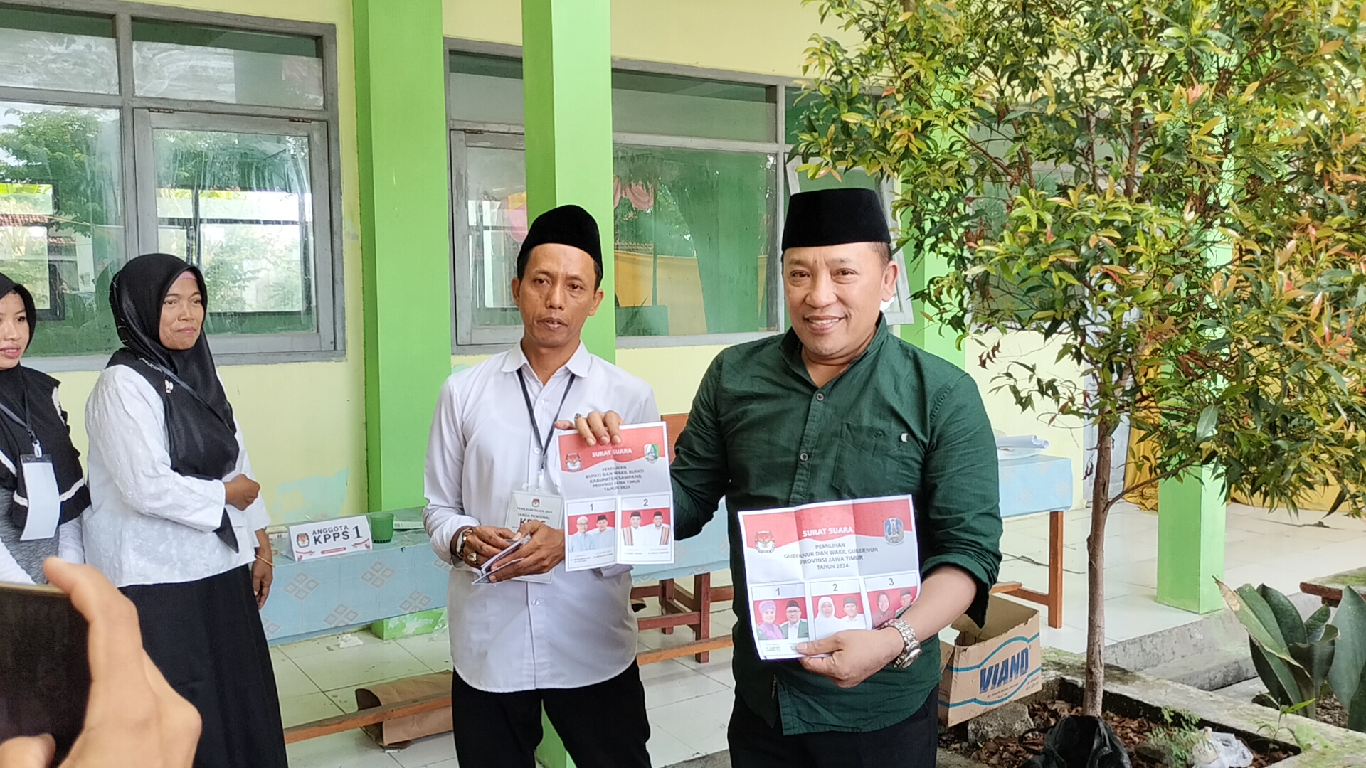 NYOBLOS: Calon Bupati Sampang H. Slamet Junaidi menunjukkan surat suara saat hendak mencoblos di TPS 09 Kelurahan Karang Dalem, Kecamatan Sampang, Rabu (27/11).