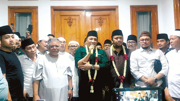 PERCAYA DIRI: Cabup Sampang Slamet Junaidi dan wakilnya, Ahmad Mahfudz (kalung melati), memberikan keterangan pers di Kelurahan Karang Dalem, Kecamatan Sampang, pada Rabu (27/11) malam.
