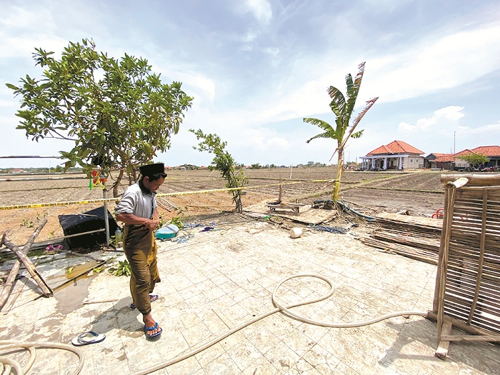 JANGAN MENDEKAT: Warga berada di sekitar sumur milik Moh. Hosen di Dusun Koberung, Desa Jarin, Kecamatan Pademawu, Pamekasan, Kamis (28/11). (MOH. IQBAL AFGANI/JPRM)