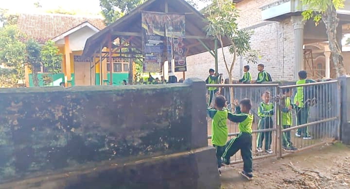 SEKOLAH DISEGEL: Siswa SDN Buddan 2, Kecamatan Tanah Merah, Bangkalan, berada di pintu pagar sekolah,&nbsp;Jumat (29/11). (HASAN BASRI UNTUK JPRM)
