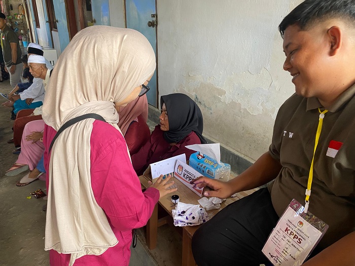 SELESAI: Pemilih mencelupkan jari ke tinta usai menyalurkan hak suara di Pilkada 2024. (MOH. IQBAL AFGANI/JPRM)