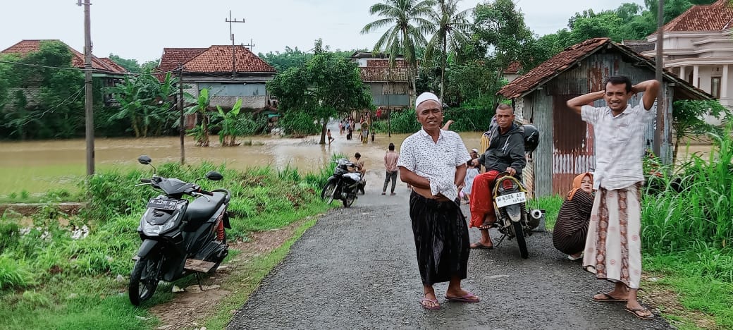TERGENANG: Warga berada di sekitar genangan air di Desa Ragang, Kecamatan Waru, Pamekasan, kemarin. (LUKMAN UNTUK JPRM)