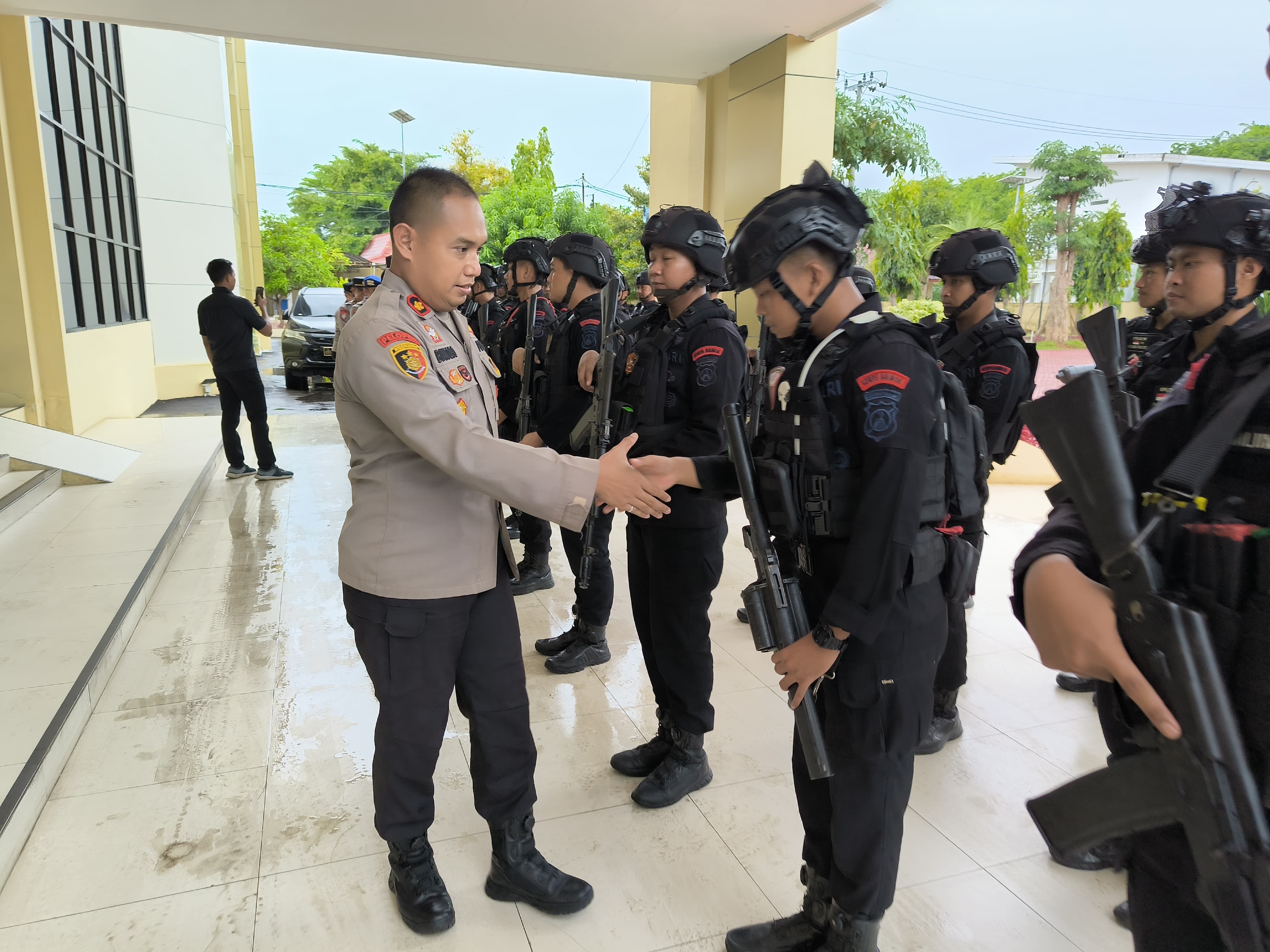 TERKENDALI: Wakapolres Sumenep Kompol Trie Sis Biantoro menyalami anggota setelah apel pelepasan BKO Polda Jatim di mapolres kemarin. (POLRES SUMENEP)