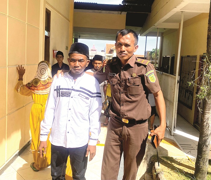 DIGIRING: Alim dikawal petugas tahanan Kejari Pamekasan Rifai menuju ruang sidang di PN Pamekasan Selasa (3/12). (MOH. IQBAL AFGANI/JPRM)