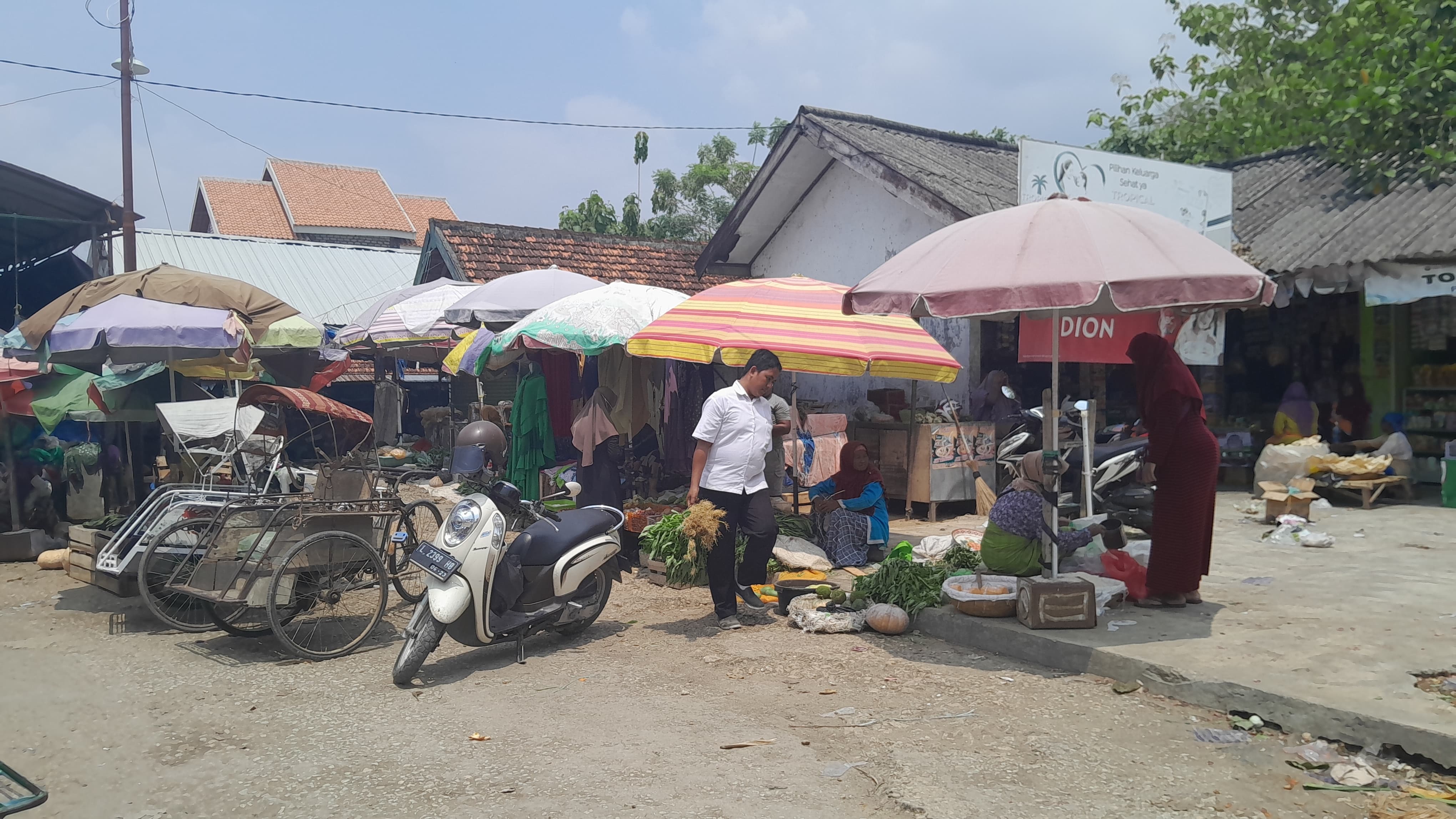 TRANSAKSI: Seorang warga berjalan membawa hasil belanjaan di Pasar Gurem, Pamekasan, beberapa waktu lalu. (KHOLIL RAMLI/JPRM)
