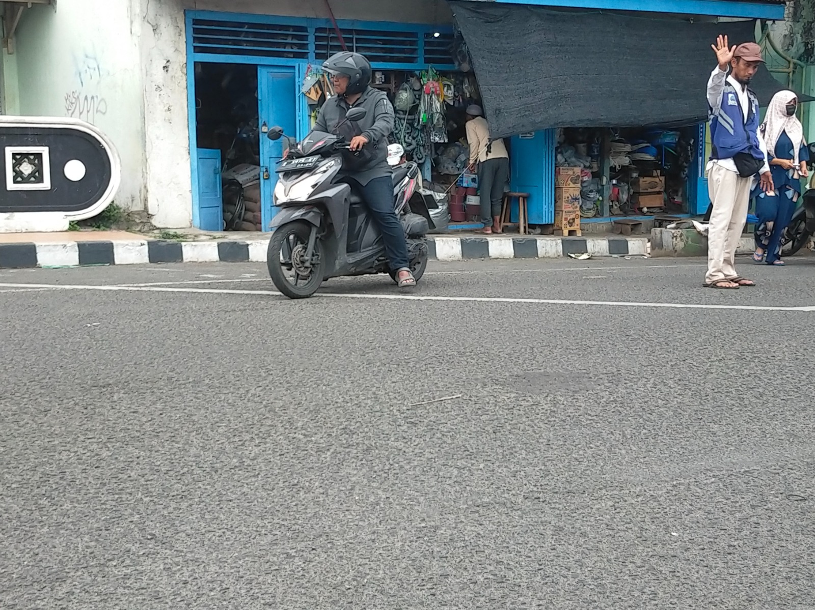 HARUS DITERTIBKAN: Juru parkir mengawal pengendara di Jalan Panglima Sudirman, Bangkalan, Senin (9/12). (VIVIN AGUSTIN HARTONO/JPRM)