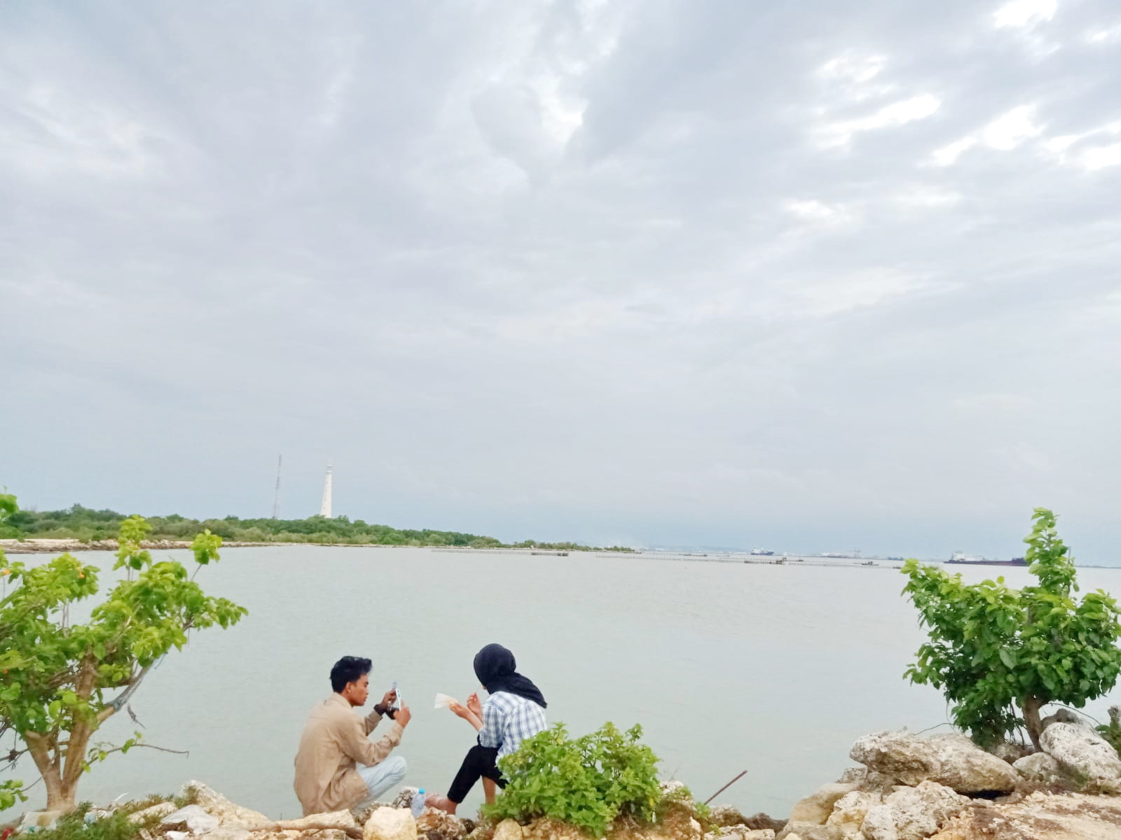 MASUK KAWASAN INDUSTRI: Warga berada di bibir pantai, Desa Sambilangan, Kecamatan Kota Bangkalan, Jumat (13/12). (IMAMUDIN/JPRM)