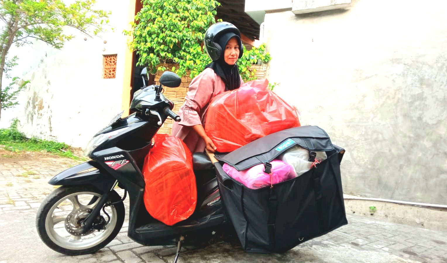 SEMANGAT: Pemilik Laundry MM Amamah menyiapkan pakaian yang hendak diantar di Kelurahan Banyuanyar, Kecamatan Sampang, Sabtu (30/11). (JUNAIDI PONDIYANTO/JPRM)