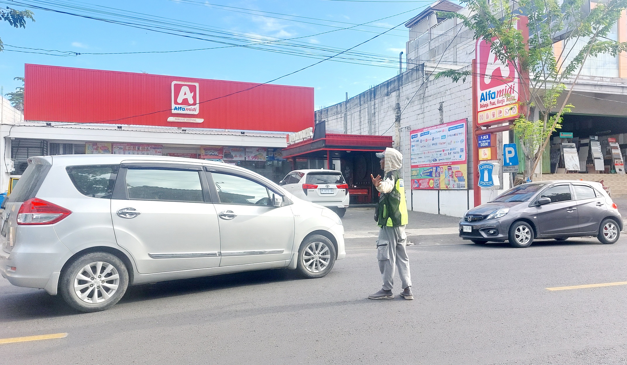 JALAN RAYA: Petugas juru parkir tengah mengawal kendaraan di Jalan Panglima Sudirman, Kota Sampang, Kamis (7/11). (JUNAIDI PONDIYANTO/JPRM)
