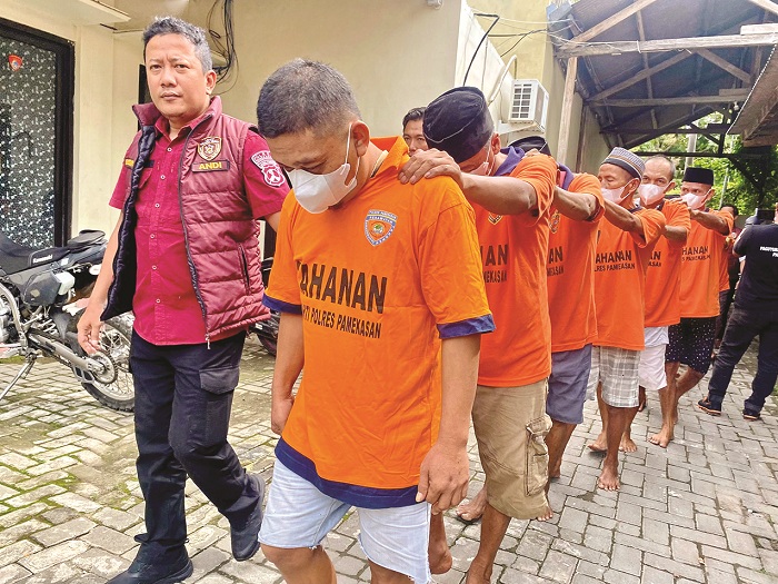 BAJU TAHANAN: Tersangka judi digiring menuju tempat konferensi pers Polres Pamekasan Rabu (18/12). (MOH. IQBAL AFGANI/JPRM)