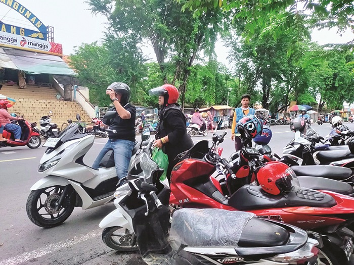 SUMBER PAD: Pengunjung Pasar Srimangunan menaiki kendaraan di area parkir tepi jalan di Jalan KH Wahid Hasyim, Senin (16/12). (ANIS BILLAH/JPRM)