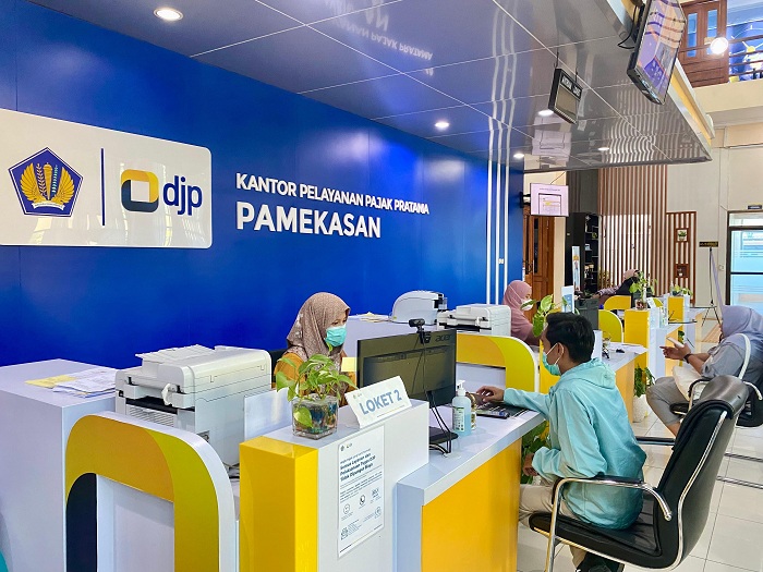 RAMAH: Petugas KPP Pratama Pamekasan melayani pengunjung, Kamis (19/12). (MOH. IQBAL AFGANI/JPRM)