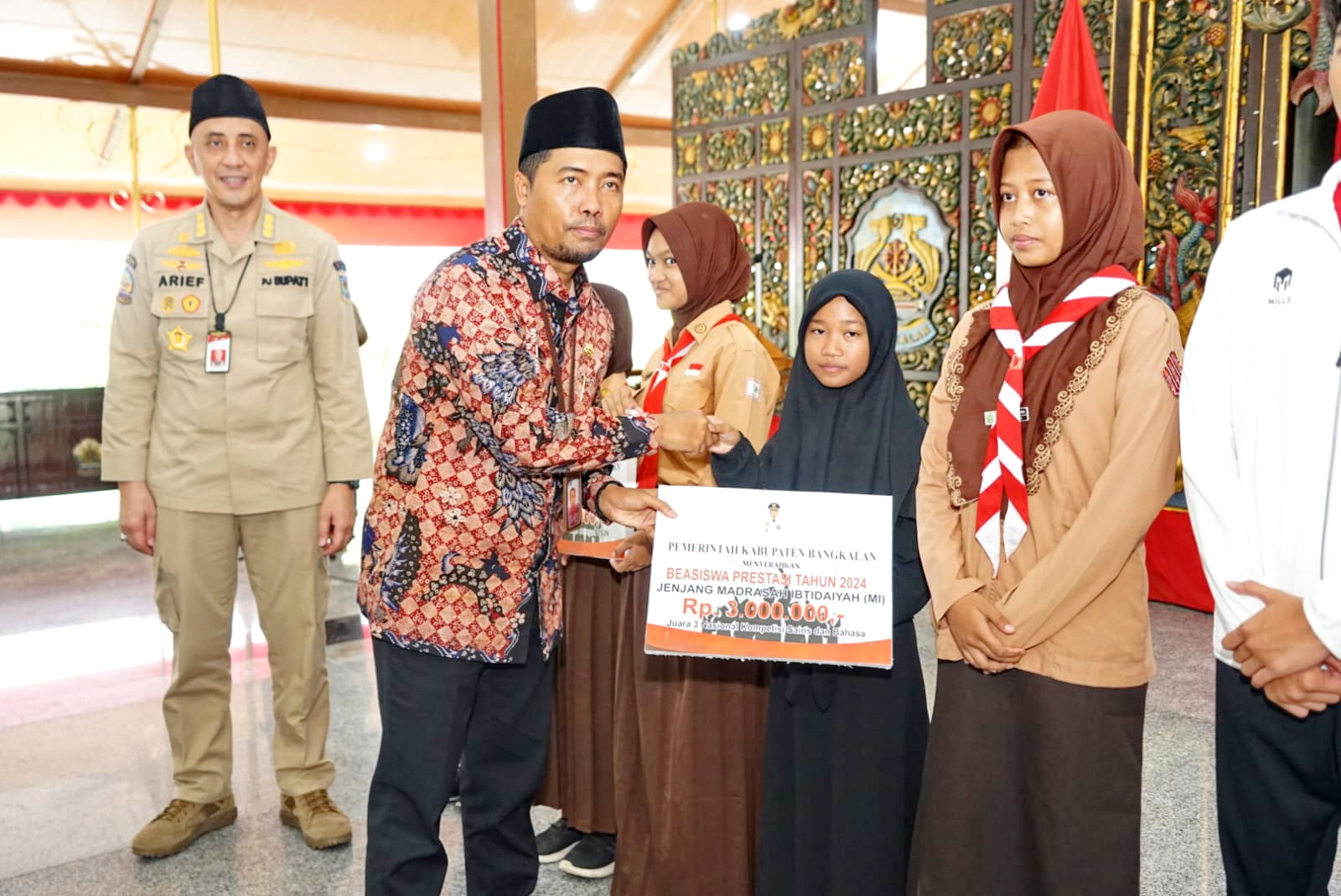DIAPRESIASI: Kepala Dispendik Bangkalan Muhammad Ya&rsquo;kub memberikan beasiswa kepada siswa berprestasi di Pendopo Agung, Jumat (20/12).