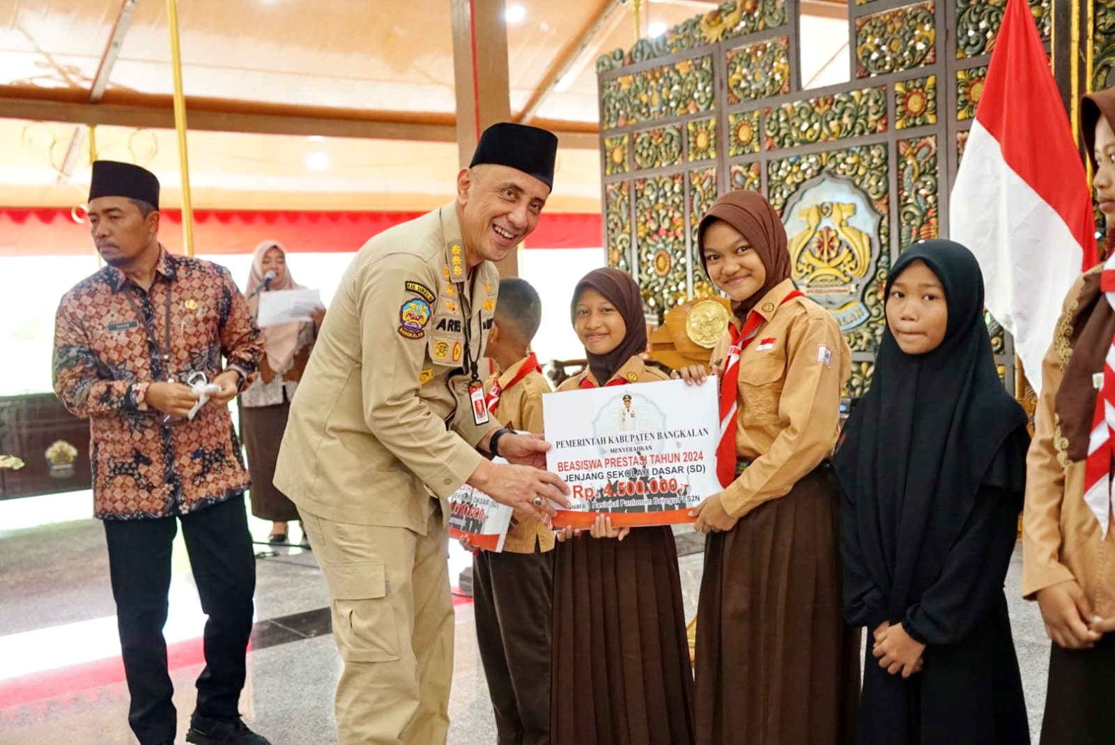 BERPRESTASI: Pj Bupati Bangkalan Arief M. Edie memberikan beasiswa pendidikan kepada siswa berprestasi di Pendopo Agung, Jumat (20/12).