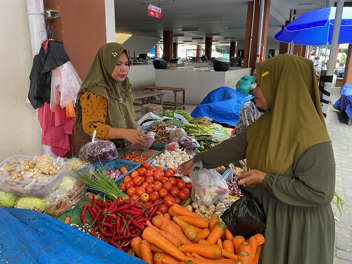 BERJUALAN: Aliyah melayani pembeli di Pasar Kolpajung, Pamekasan, Rabu (25/12). (AYU LATIFAH/JPRM)