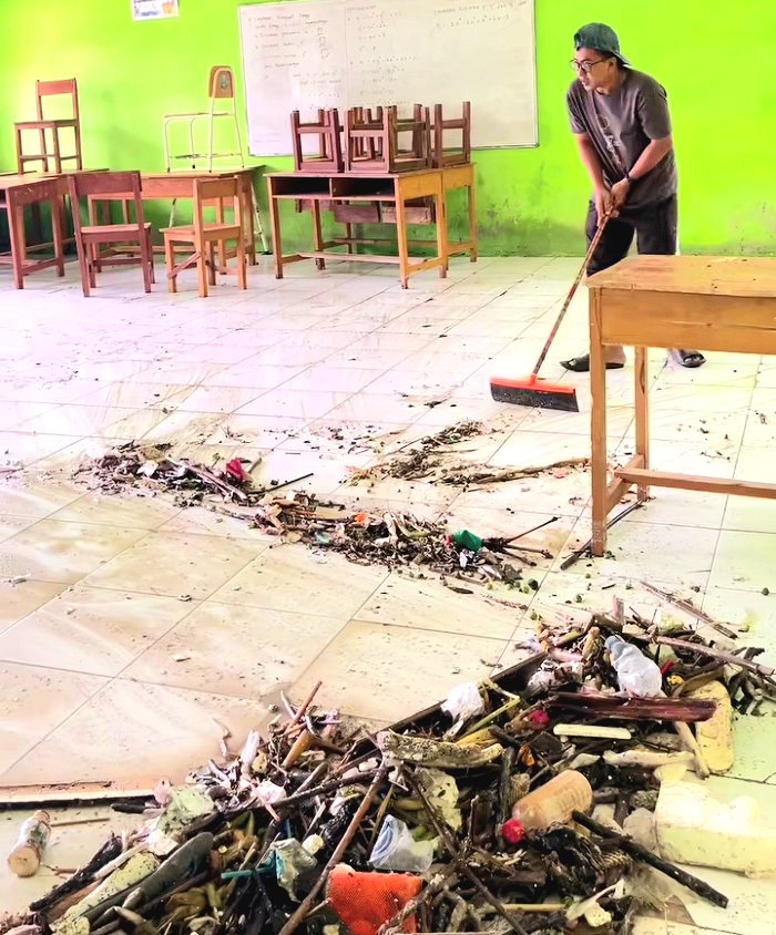 FAKTOR ALAM: Guru SMKN 3 Sampang membersihkan ruang kelas setelah terendam banjir rob Minggu (15/12). (SMKN 3 SAMPANG UNTUK JPRM)
