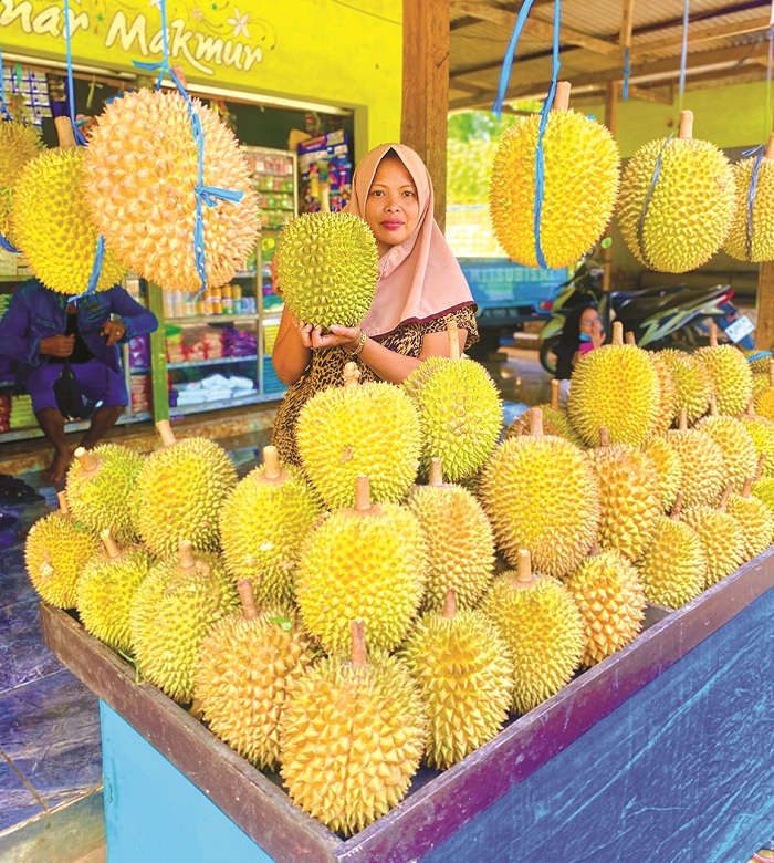 ANDALAN: Salamah menunjukkan salah satu durian kasor di tokonya di Jalan Raya Lebbek&ndash;Pegantenan, Pamekasan, Jumat (27/12). (MOH. IQBAL AFGANI/JPRM)