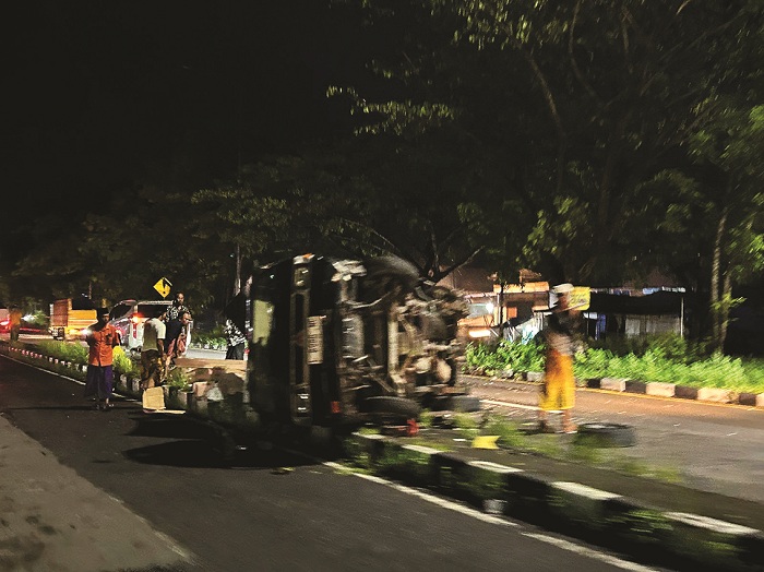 JUNGKIR BALIK: Petugas kepolisian bersama masyarakat mengevakuasi kendaraan pikap yang terlibat laka di akses Jembatan Suramadu, Sabtu (28/12). (VIVIN AGUSTIN HARTONO/JPRM)