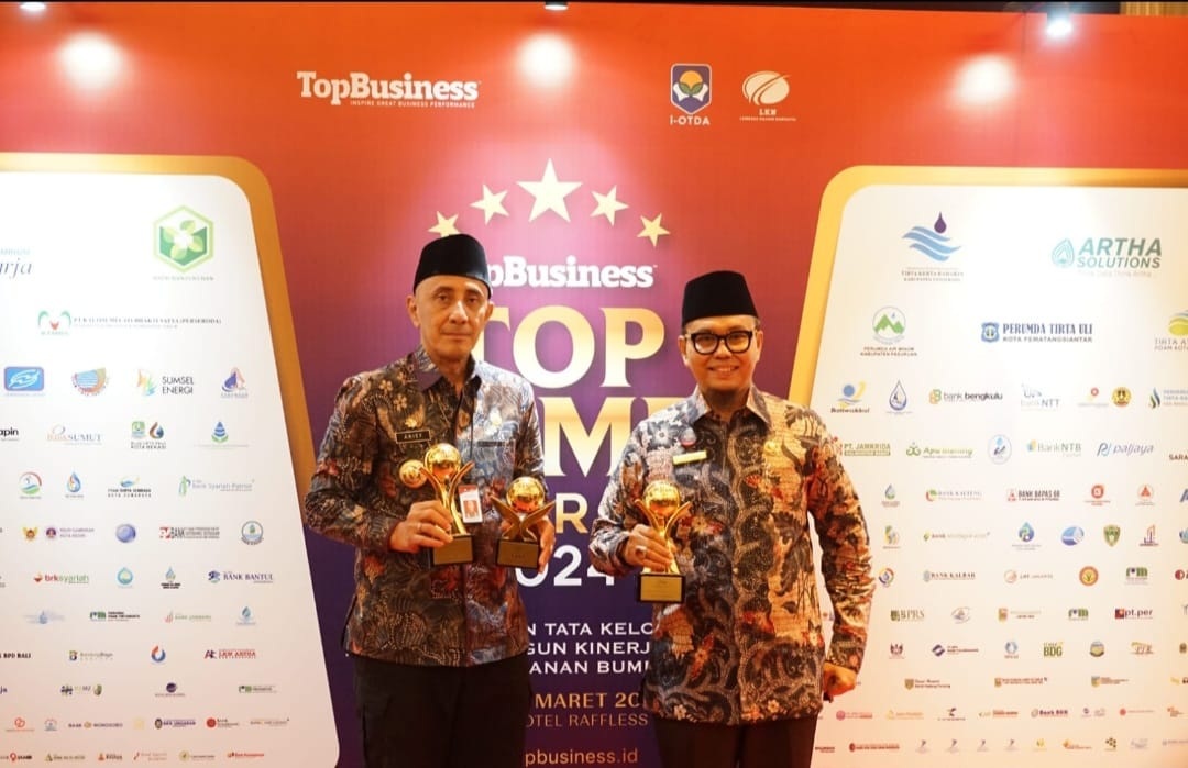 KEREN: Direktur PUDAM Sumber Sejahtera Sjobirin Hasan (kanan) dan Pj Bupati Bangkalan Arief M. Edie menunjukkan trofi penghargaan dari Top Business di Hotel Raffles Jakarta, Rabu (20/3). (PUDAM UNTUK)