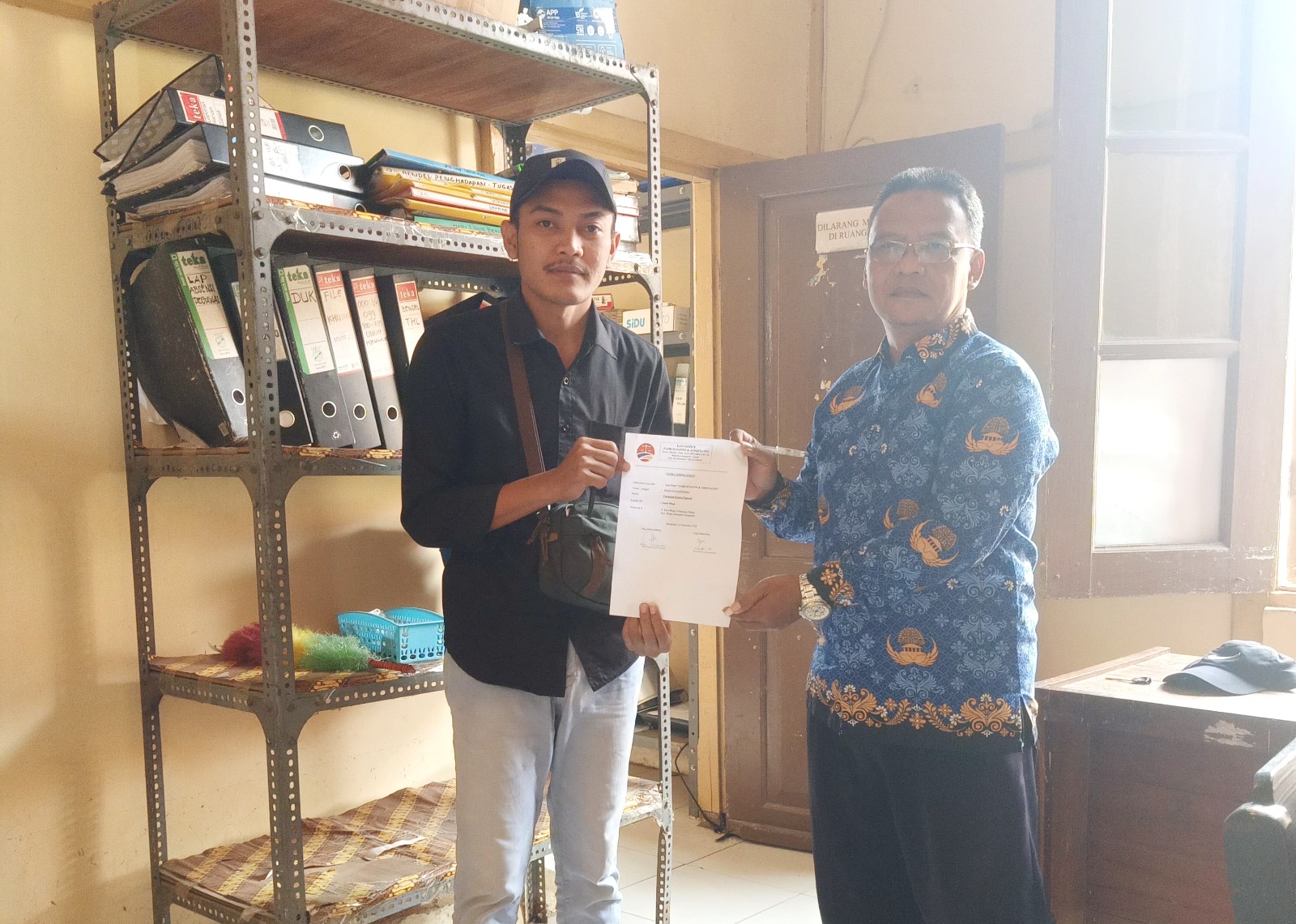 BUKA SUARA: Perangkat Desa Lombang Laok Moch. Solehuddin (kiri) menyerahkan surat kontra teguran ke kantor Kecamatan Blega, Selasa (17/12). (ZEINAL ABIDIN/JPRM)