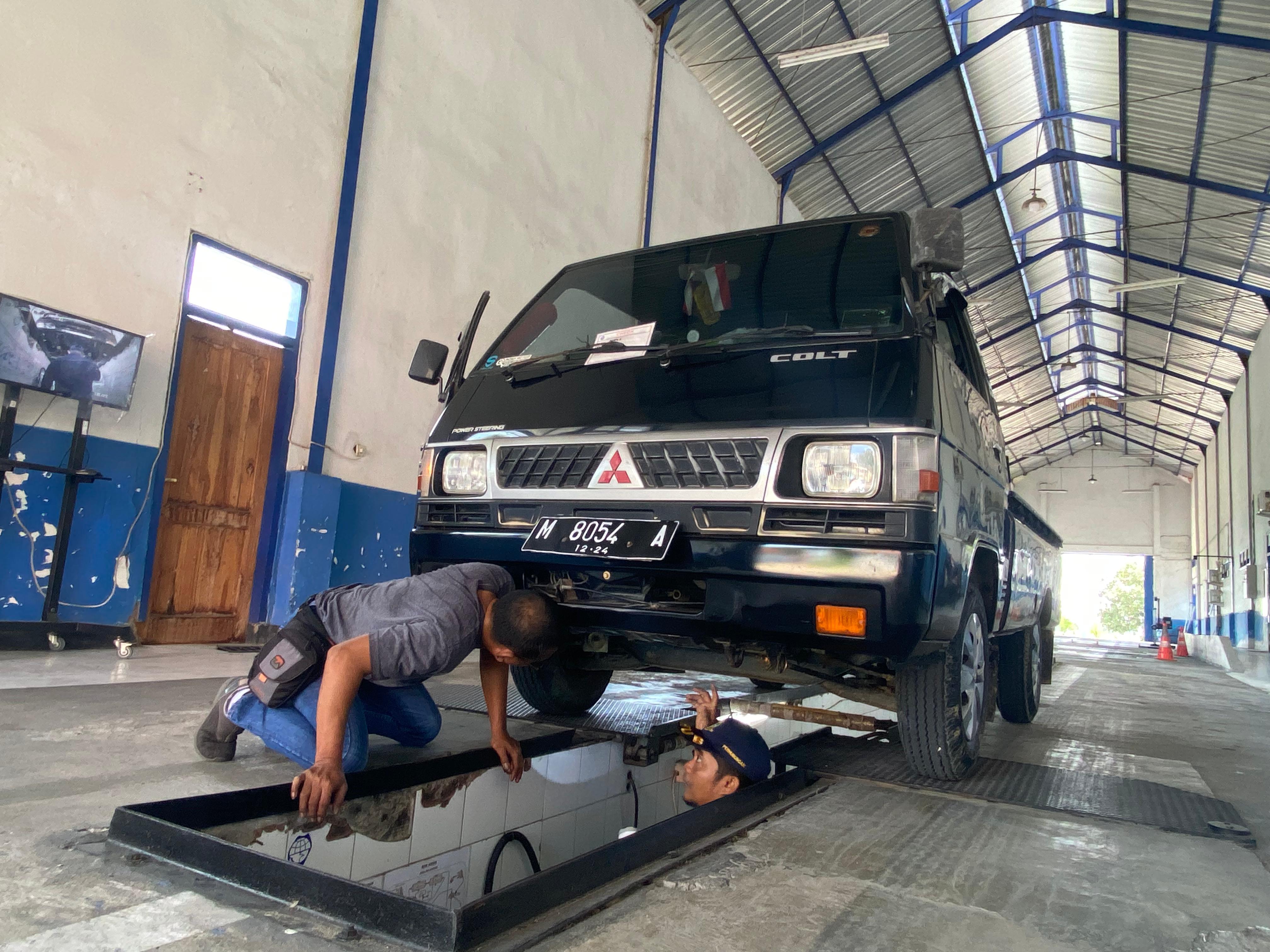 CEK KELAYAKAN: Petugas uji kir Jufri sedang mengecek kelayakan mobil di Desa Peltong, Kecamatan Larangan, Senin (30/12). (AYU LATIFAH/JPRM)