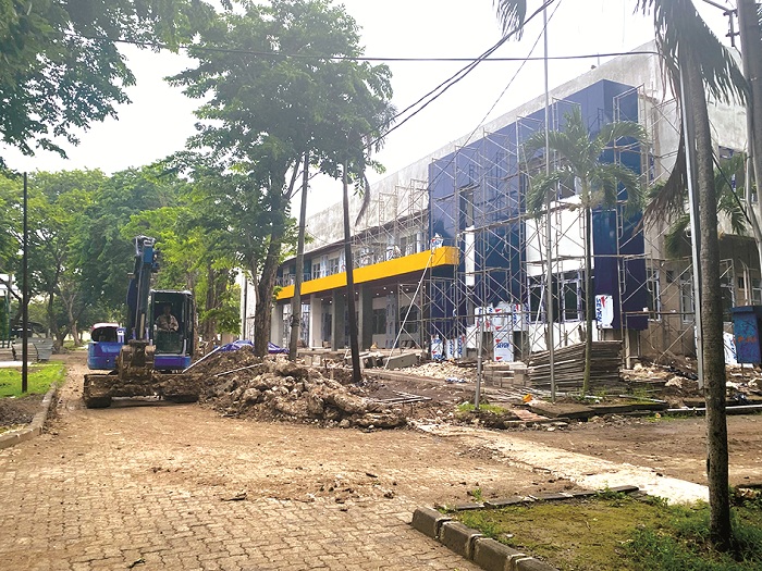 LOMPAT TAHUN: Seorang pekerja proyek pembangunan gedung inovasi teaching industry UTM Bangkalan mengoperasikan alat berat, Senin (30/12/2024). (JUPRI/JPRM)