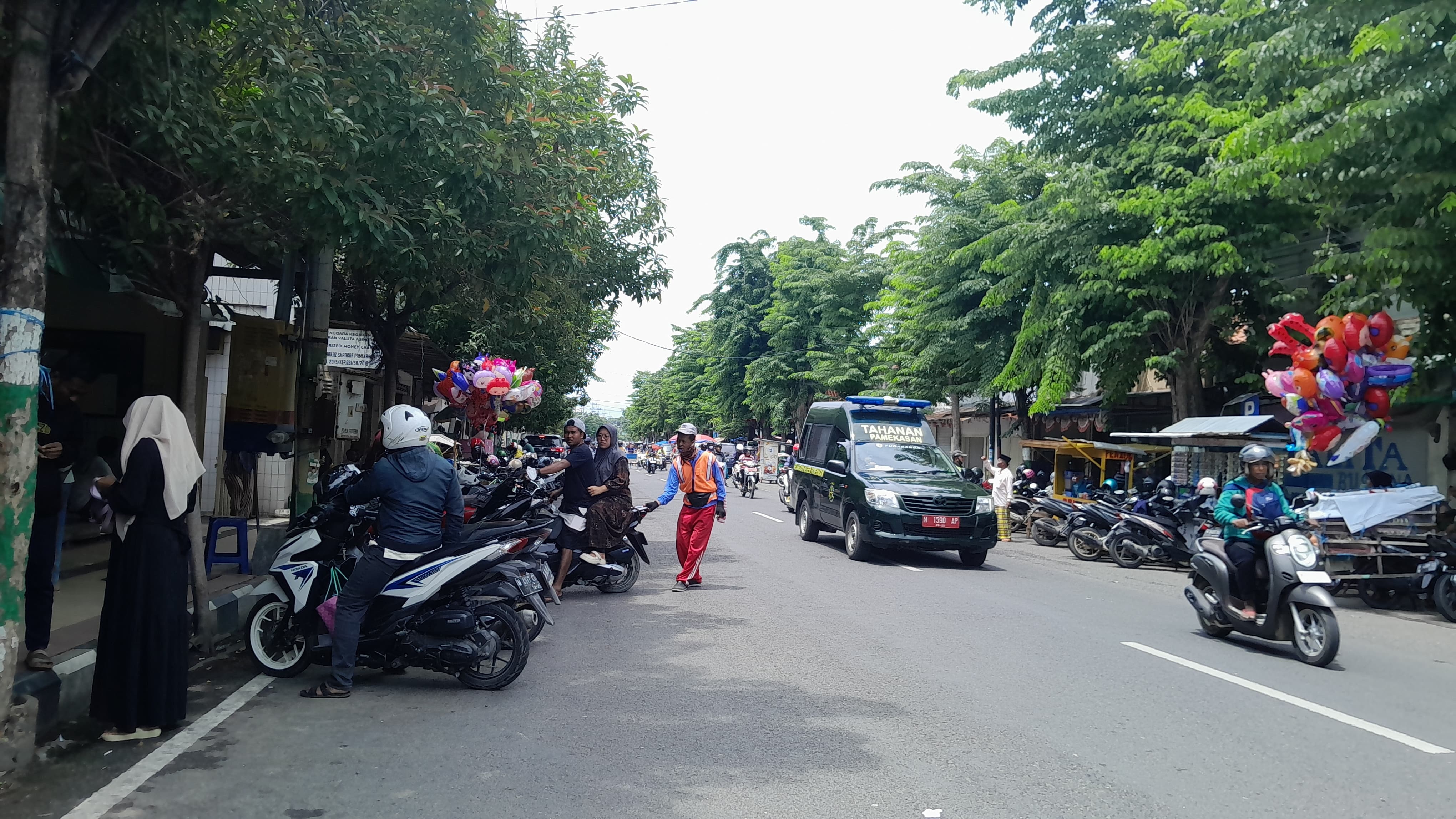 PARKIR BERLANGGANAN: Juru parkir mengatur kendaraan Jalan Diponegoro, Pamekasan, Kamis (2/1). (KHOLIL RAMLI/JPRM)