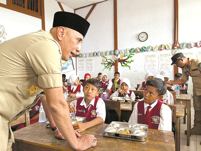 SISWA SENANG: Pj Bupati Bangkalan Arief M. Edie memantau pendistribusian makanan bergizi gratis di SDN Patereman 1, Kecamatan Modung, Senin (6/1). (ZEINAL ABIDIN/JPRM)